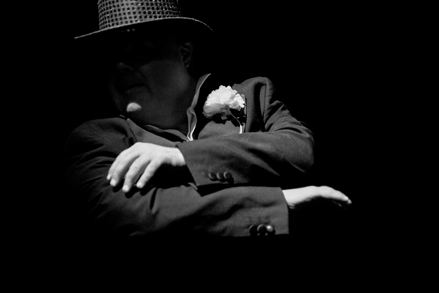 Black and white photo of Graham with a sequined top hat and arms crossed in front of him